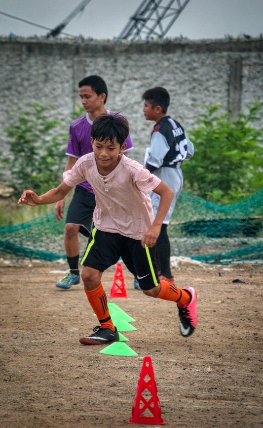 An athlete sprinting through training cones